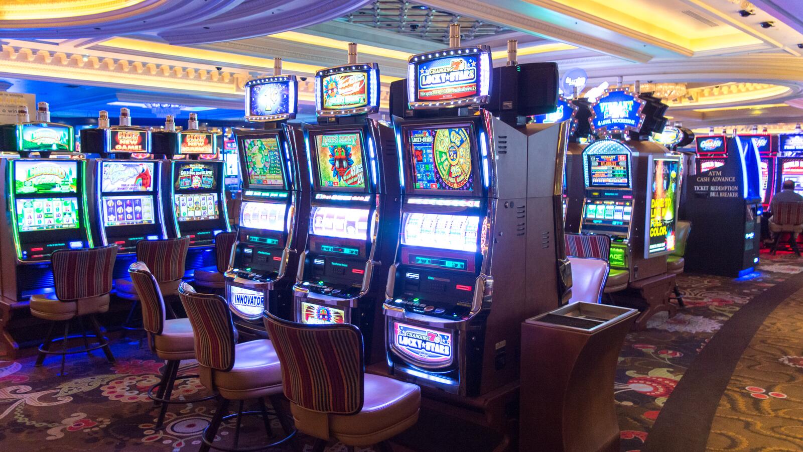 Rad av moderna, upplysta spelautomater på ett casinogolv